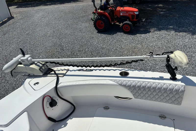Slide: The Image of 2022 Twin Vee 240 GFX CC boat with MotorGuide trolling motor, parked near a red tractor. - 26