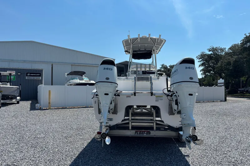 Slide: The Image of 2022 Twin Vee 240 GFX CC boat with dual Suzuki 140 engines at a marina. - 3