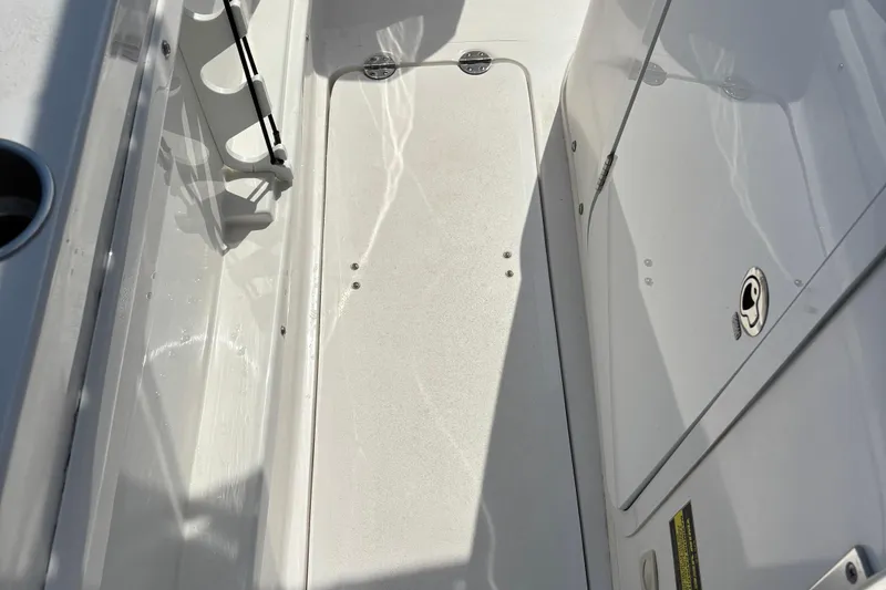 Slide: The Image of 2022 Twin Vee 240 GFX CC boat interior, featuring storage compartment and rod holders. - 31
