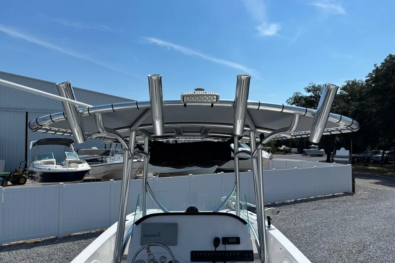 Slide: The Image of 2022 Twin Vee 240 GFX CC boat with T-top and rod holders in a marina. - 34