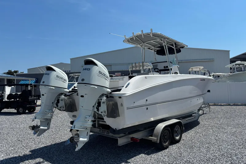 Slide: The Image of 2022 Twin Vee 240 GFX CC boat with dual Suzuki outboard motors on a trailer. - 4