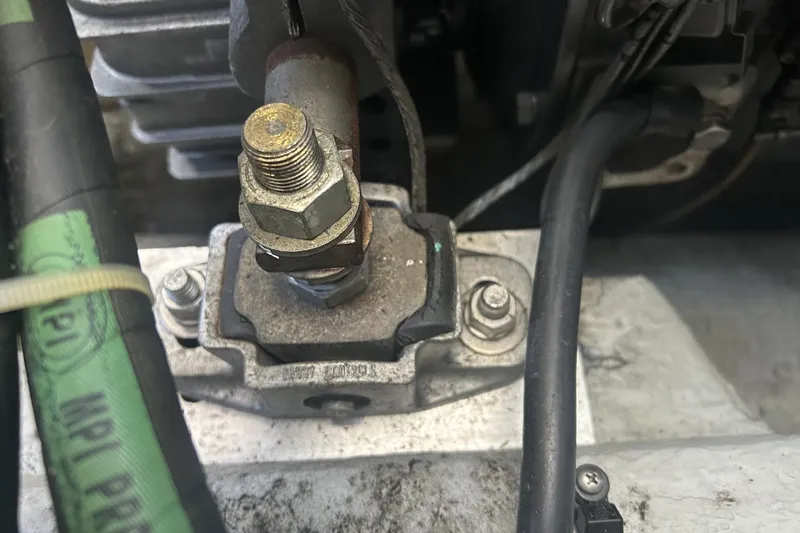 Slide: The Image of Close-up of a 1998 Mainship Pilot 30 engine component with bolts and cables. - 14