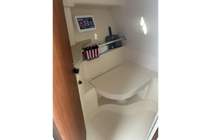 Slide: The Image of 1998 Mainship Pilot 30 boat interior with compact bathroom and storage shelf. - 16