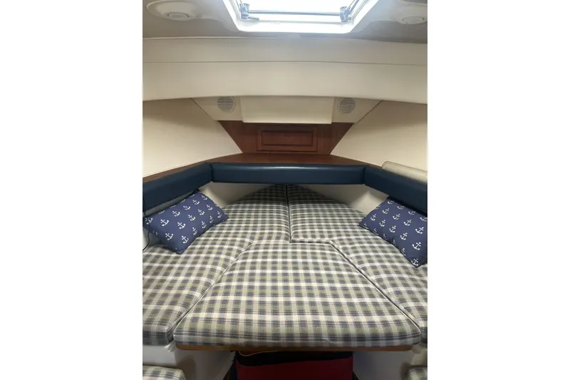 Slide: The Image of 1998 Mainship Pilot 30 cabin interior with plaid bedding and anchor-themed pillows. - 20