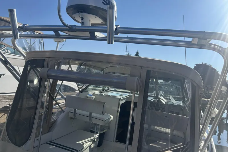 Slide: The Image of 1998 Mainship Pilot 30 boat with radar, docked under clear blue sky. - 6