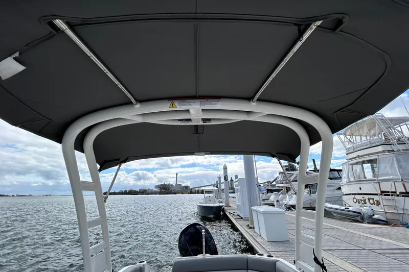 Slide: The Image of 2022 NauticStar 243 DC boat docked at marina, view from under canopy. - 12