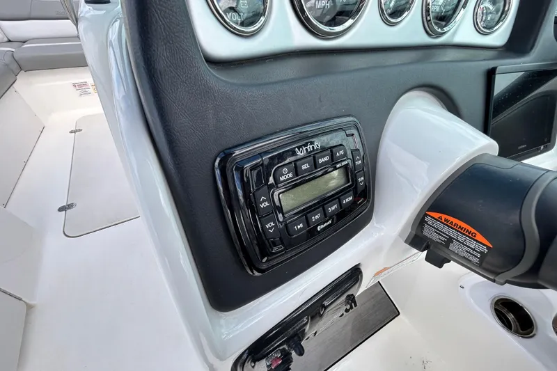 Slide: The Image of 2022 NauticStar 243 DC dashboard with Infinity stereo system and control panel. - 18