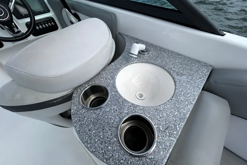 Slide: The Image of 2022 NauticStar 243 DC boat interior with sink and cup holders. - 5