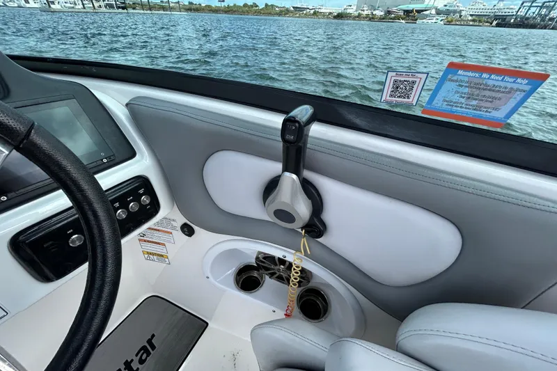 Slide: The Image of 2022 NauticStar 243 DC boat interior with steering wheel and control panel. - 6