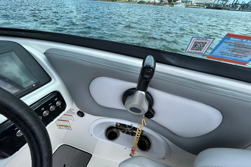 Slide: The Image of 2022 NauticStar 243 DC boat dashboard with controls and water view. - 7