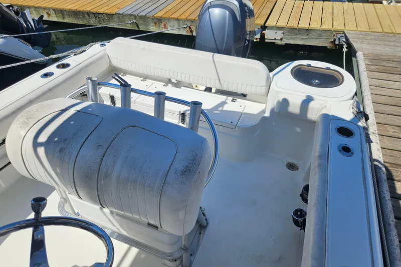 Slide: The Image of 2012 Sea Fox 226CC boat interior with seating and fishing rod holders at dock. - 4