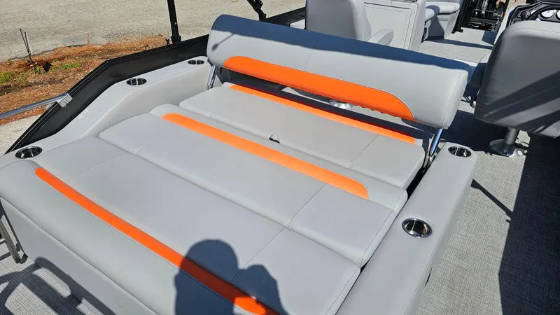 Slide: The Image of 2025 Bentley Pontoons Legacy 243 Swingback on trailer, sleek design under cloudy sky. - 16