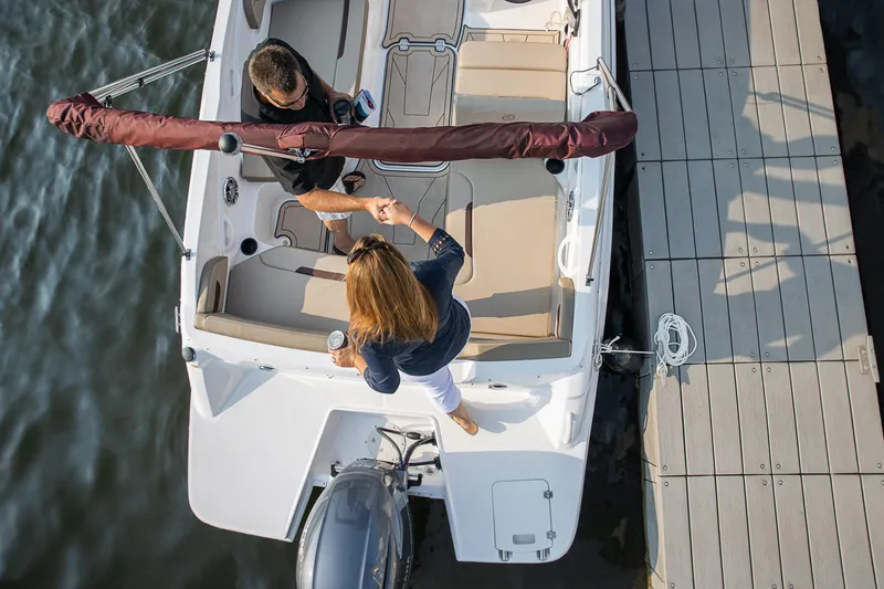 Slide: The Image of Couple docking a 2025 Hurricane SunDeck Sport 205 OB boat at a marina. - 29
