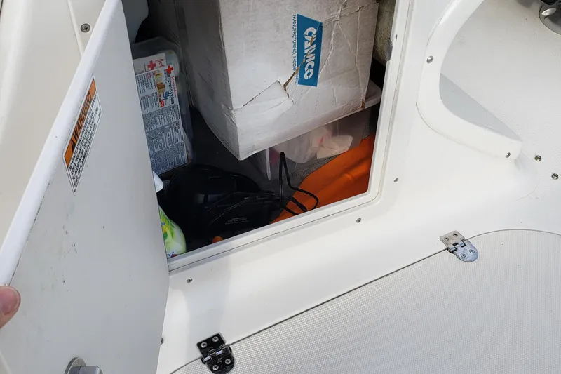 Slide: The Image of Open storage compartment in 2015 Starcraft Limited 2000 IO boat, containing various items. - 22