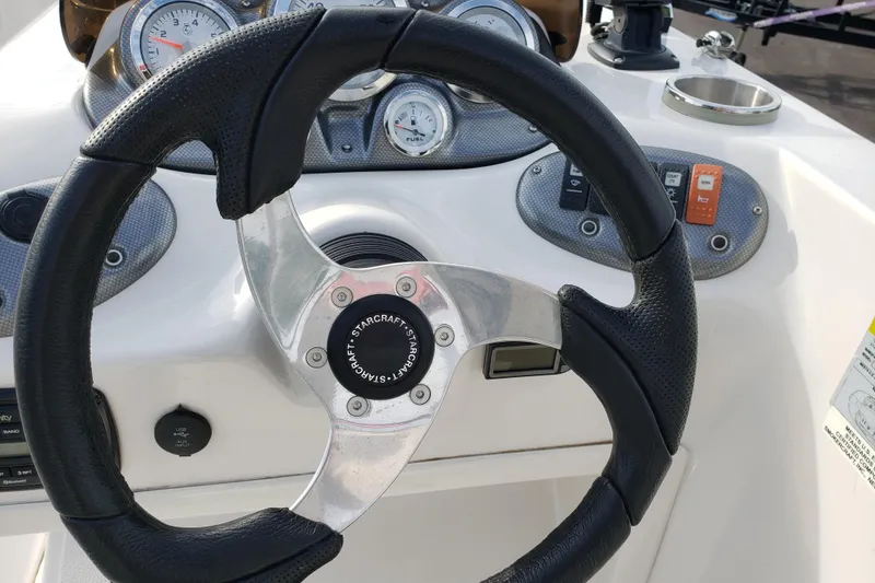 Slide: The Image of Steering wheel of 2015 Starcraft Limited 2000 IO boat with dashboard controls. - 8