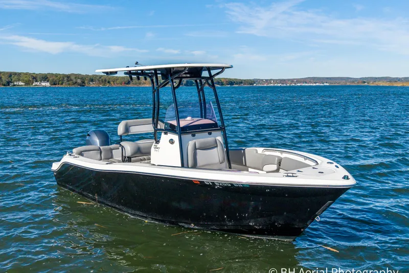 The Image of 2021 NauticStar 2102 Legacy boat on a calm lake under clear skies. - 0