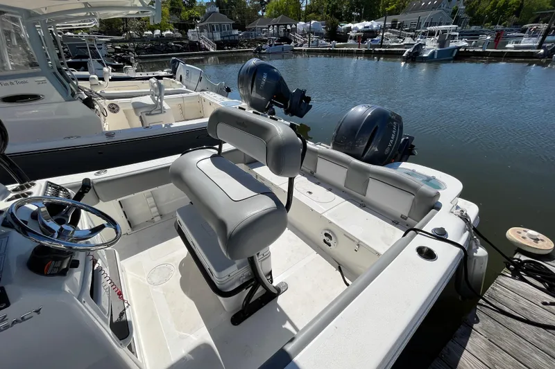Slide: The Image of 2021 NauticStar 2102 Legacy boat interior with dual engines docked at marina. - 10