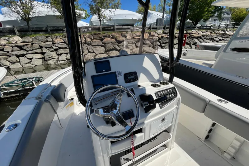 Slide: The Image of 2021 NauticStar 2102 Legacy boat cockpit with steering wheel and control panel. - 11