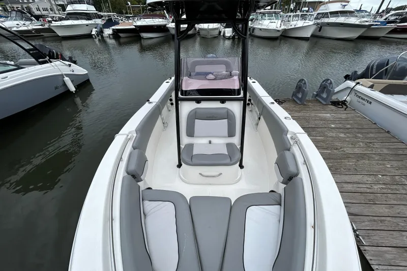 Slide: The Image of 2021 NauticStar 2102 Legacy boat docked, featuring spacious seating and sleek design. - 13