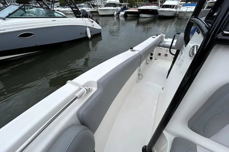 Slide: The Image of 2021 NauticStar 2102 Legacy boat interior at marina, featuring sleek seating and modern design. - 15