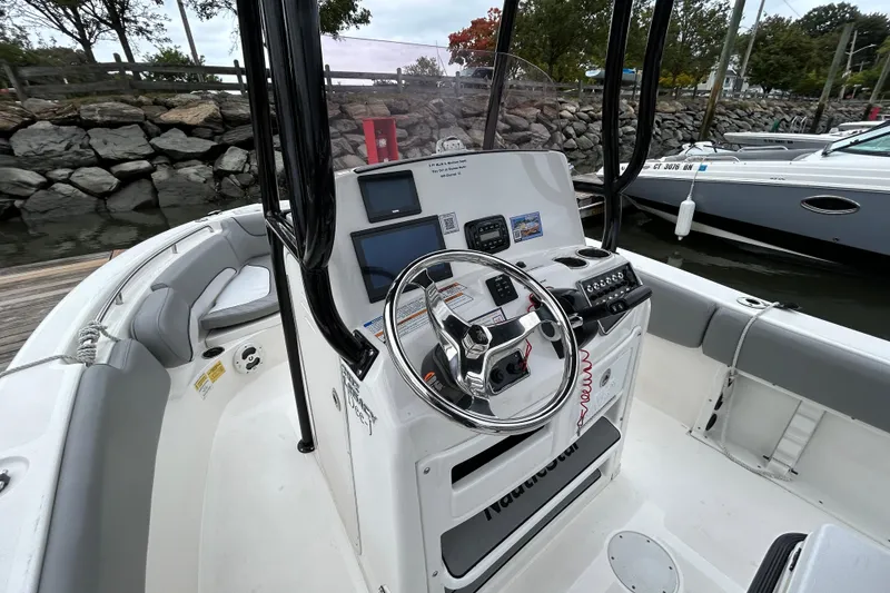 Slide: The Image of 2021 NauticStar 2102 Legacy boat console with steering wheel and navigation equipment. - 18