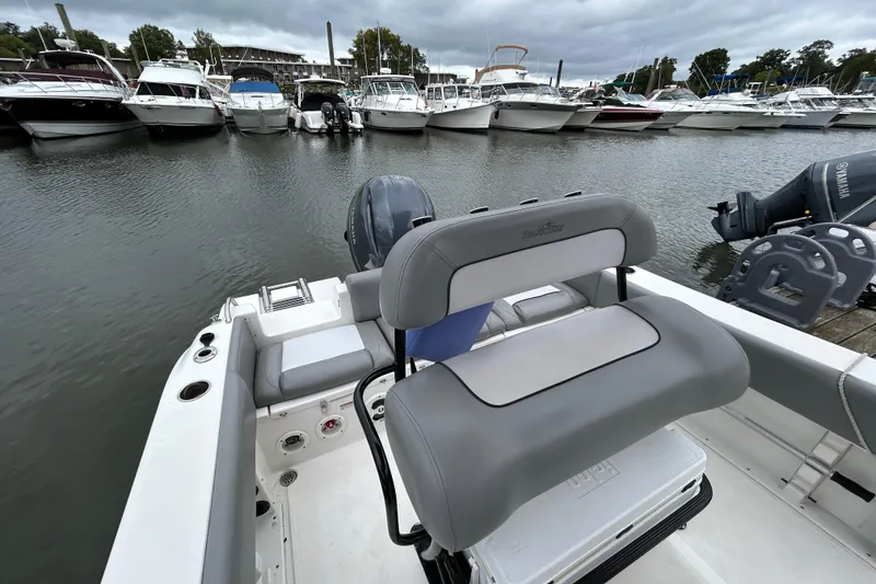 Slide: The Image of 2021 NauticStar 2102 Legacy boat docked in a marina with other vessels. - 24