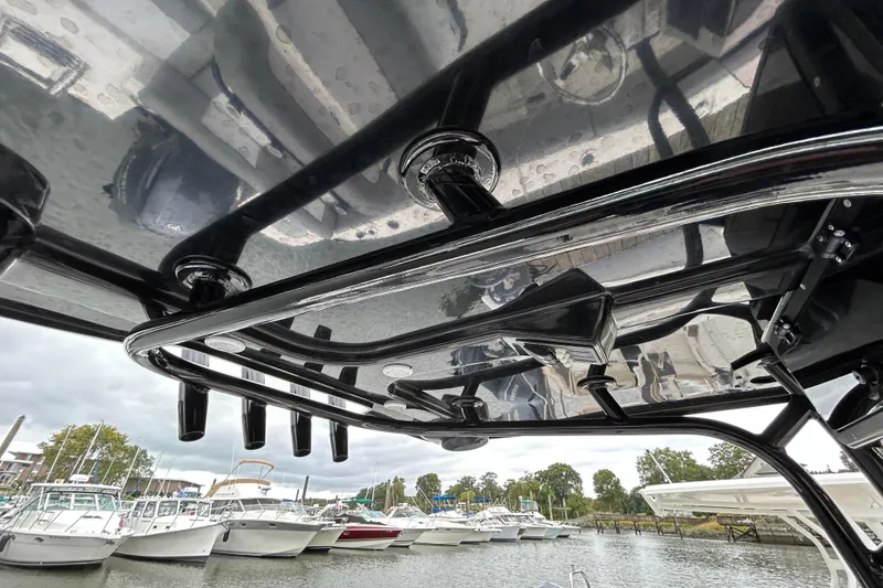 Slide: The Image of 2021 NauticStar 2102 Legacy boat with sleek T-top and rod holders at marina. - 25