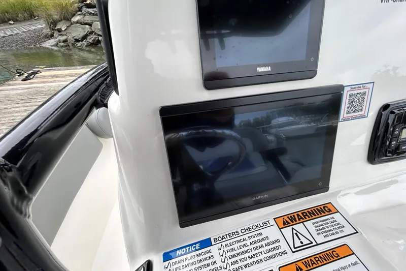 Slide: The Image of 2021 NauticStar 2102 Legacy boat dashboard with Yamaha and Garmin displays, safety warnings visible. - 27