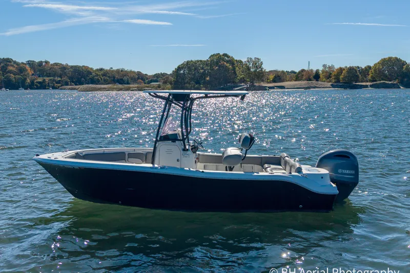 Slide: The Image of 2021 NauticStar 2102 Legacy boat on a sunny lake with scenic background. - 3