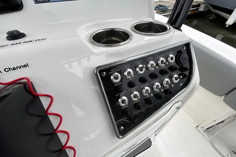 Slide: The Image of Control panel of 2021 NauticStar 2102 Legacy boat with switches and cup holders. - 30