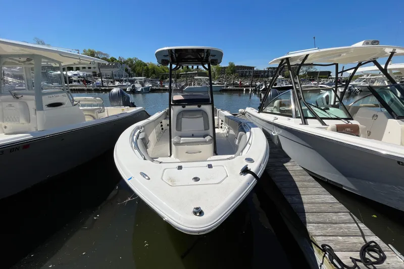Slide: The Image of 2021 NauticStar 2102 Legacy boat docked between two other boats at a marina. - 8