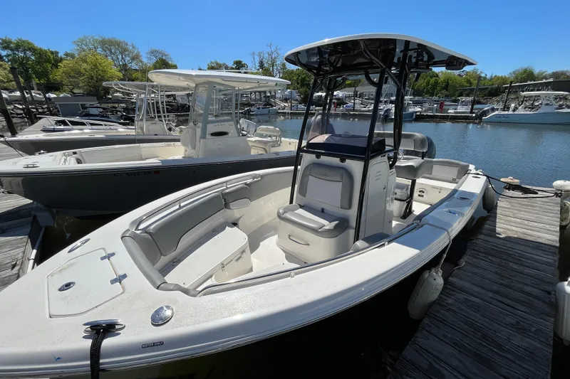 Slide: The Image of 2021 NauticStar 2102 Legacy boat docked at marina, featuring spacious seating and sleek design. - 9