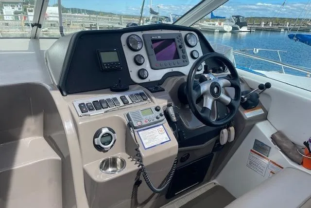 Slide: The Image of 2011 Cruisers Yachts 360 Express helm with navigation controls and steering wheel. - 10