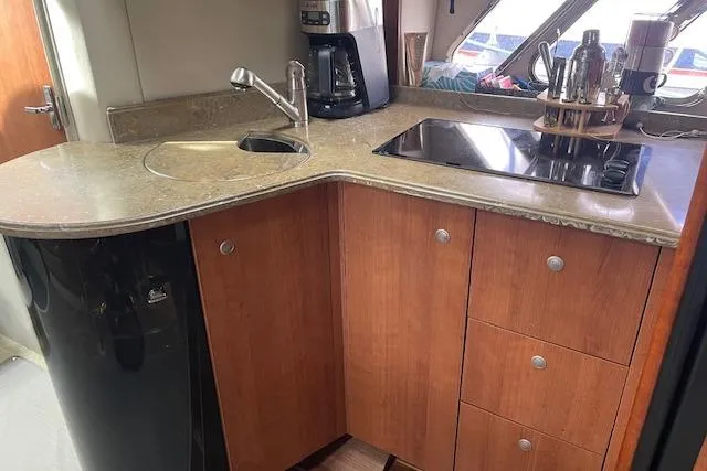 Slide: The Image of 2011 Cruisers Yachts 360 Express kitchen with sink, stove, and wooden cabinetry. - 22