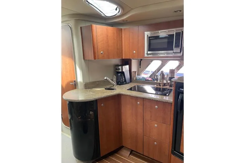 Slide: The Image of 2011 Cruisers Yachts 360 Express kitchen with wood cabinets, microwave, and countertop appliances. - 23