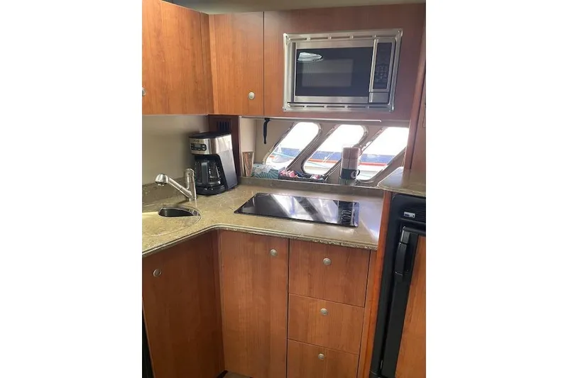 Slide: The Image of 2011 Cruisers Yachts 360 Express kitchen with microwave, coffee maker, and sleek cabinetry. - 26