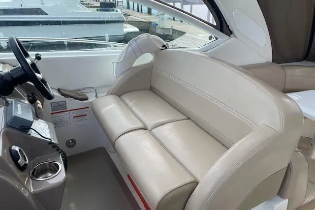 Slide: The Image of 2011 Cruisers Yachts 360 Express interior with beige seating and helm. - 29