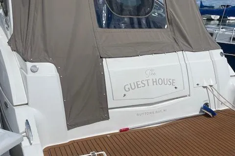 Slide: The Image of 2011 Cruisers Yachts 360 Express docked, featuring "The Guest House" nameplate, Suttons Bay, MI. - 3