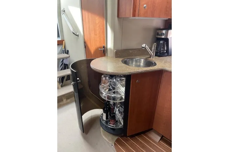 Slide: The Image of 2011 Cruisers Yachts 360 Express interior with sink, coffee maker, and glass storage. - 31
