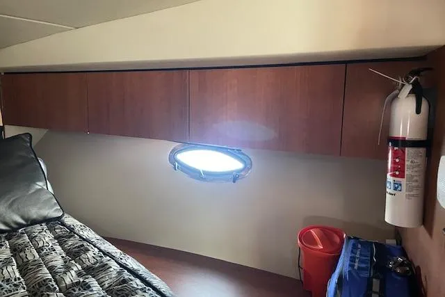 Slide: The Image of 2011 Cruisers Yachts 360 Express cabin interior with porthole, fire extinguisher, and storage cabinets. - 35