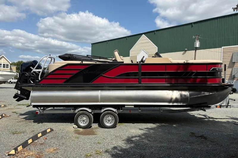 The Image of 2026 Bentley Pontoons 223 Elite Admiral on trailer, red and black design, outdoor setting. - 0