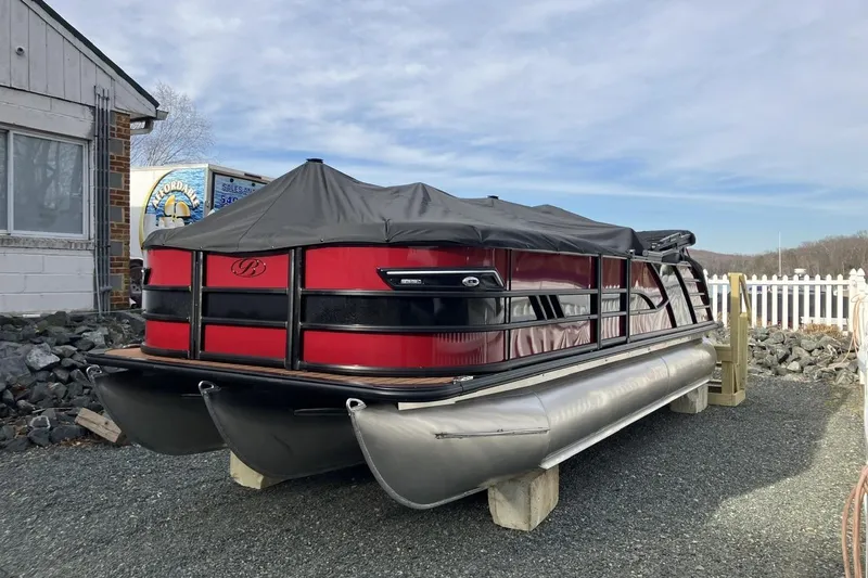 Slide: The Image of 2026 Bentley Pontoons 223 Elite Admiral pontoon boat with cover, parked on gravel. - 2