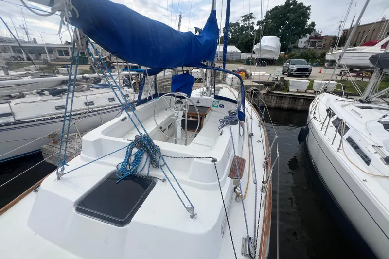 Slide: The Image of 1985 C&C Landfall 39 sailboat docked, featuring a blue sail cover and spacious deck. - 10