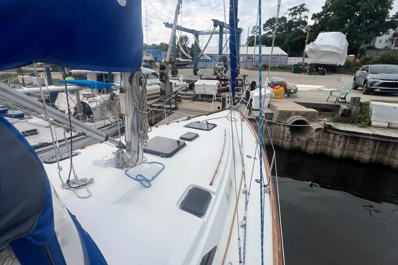 Slide: The Image of 1985 C&C Landfall 39 sailboat docked at marina, surrounded by other boats and equipment. - 16