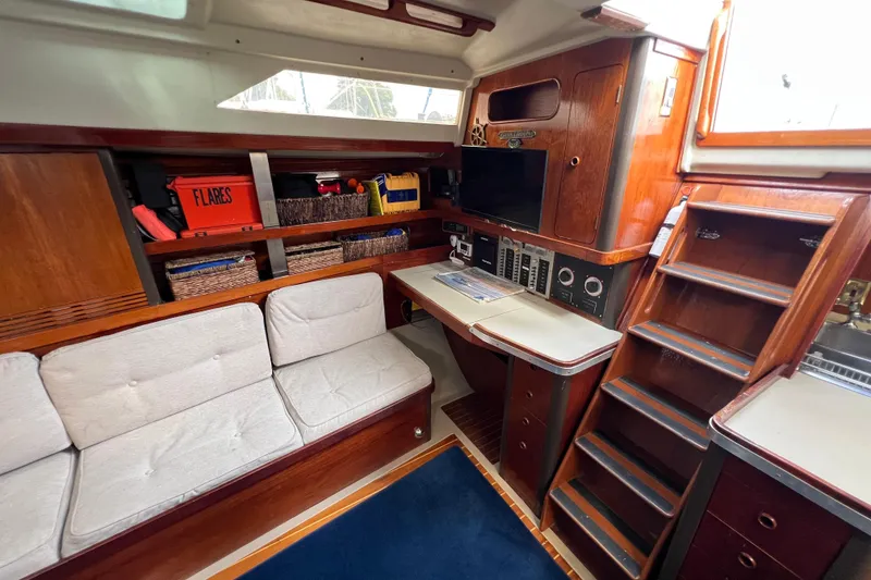 Slide: The Image of 1985 C&C Landfall 39 yacht interior with wooden cabinetry, navigation station, and cozy seating area. - 26