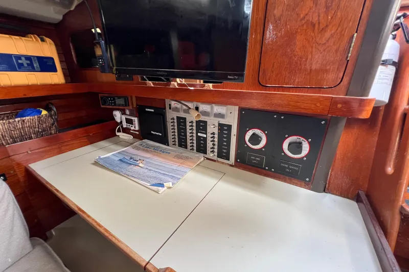 Slide: The Image of Navigation station on 1985 C&C Landfall 39 sailboat with control panels and TV. - 27