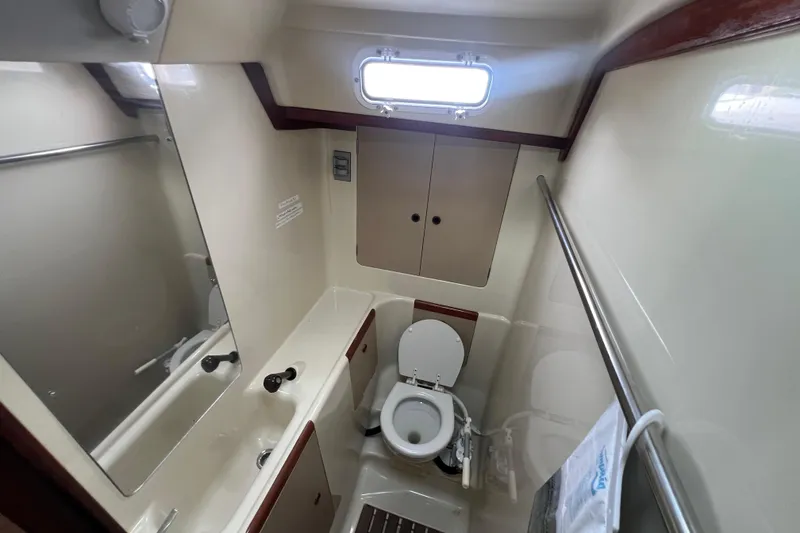 Slide: The Image of 1985 C&C Landfall 39 yacht bathroom with toilet, sink, and storage cabinets. - 33