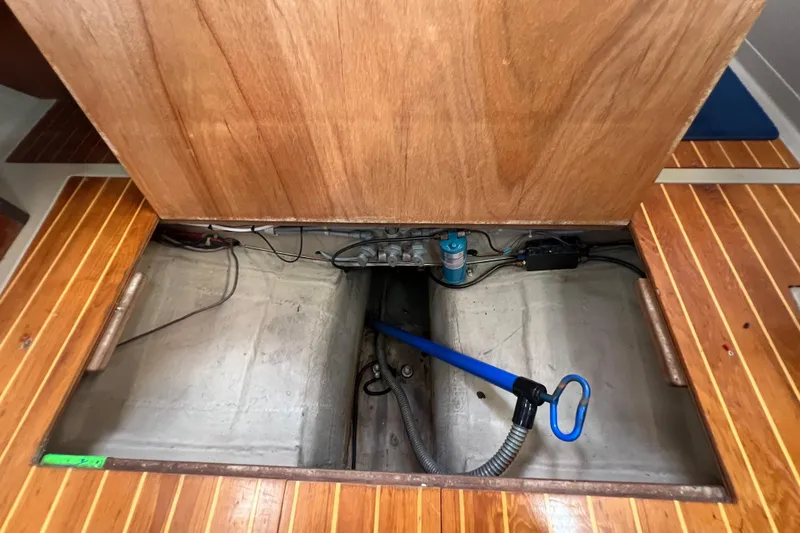 Slide: The Image of Open engine compartment of 1985 C&C Landfall 39 sailboat, showing interior components and wooden flooring. - 56