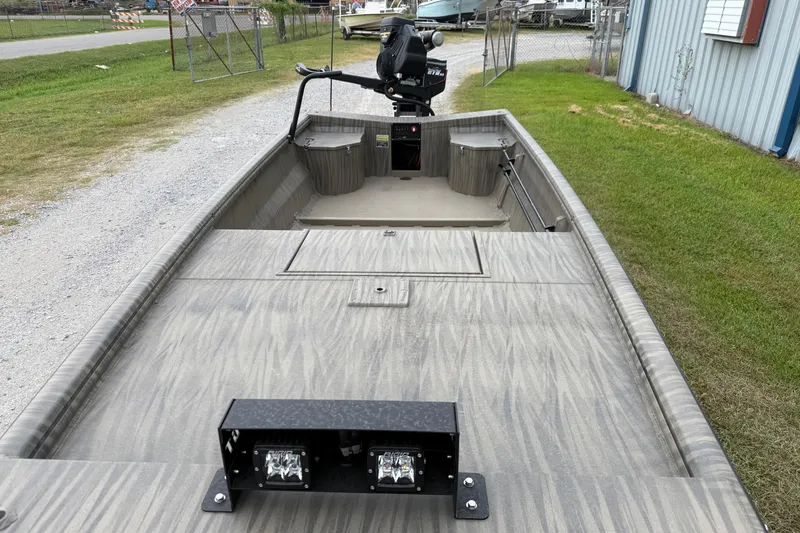 Slide: The Image of 2026 Gator Tail 1754 Extreme boat with camouflage design, parked on gravel near a building. - 3