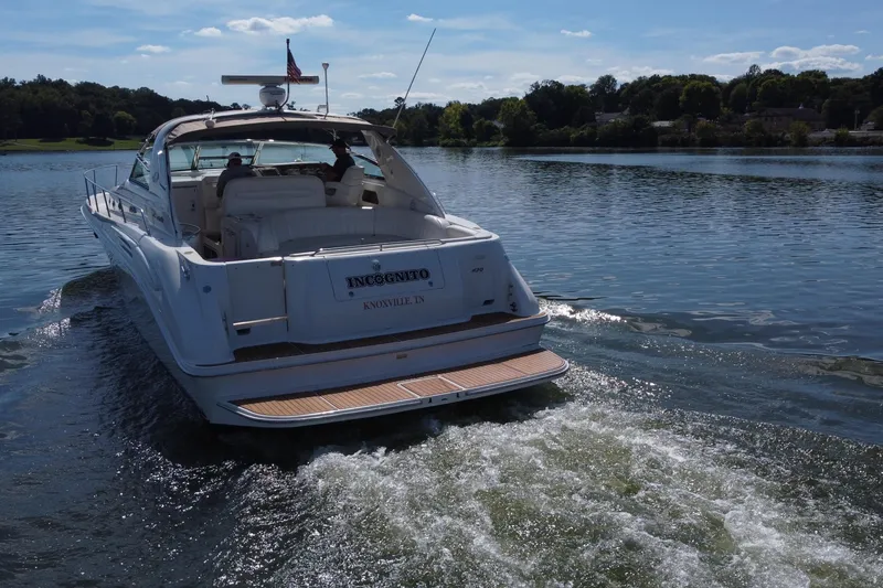 Slide: The Image of 1997 Sea Ray 450 Sundancer yacht cruising on a serene lake under a clear blue sky. - 10